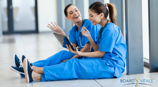 two female young nurses having fun with tablet computer during break
